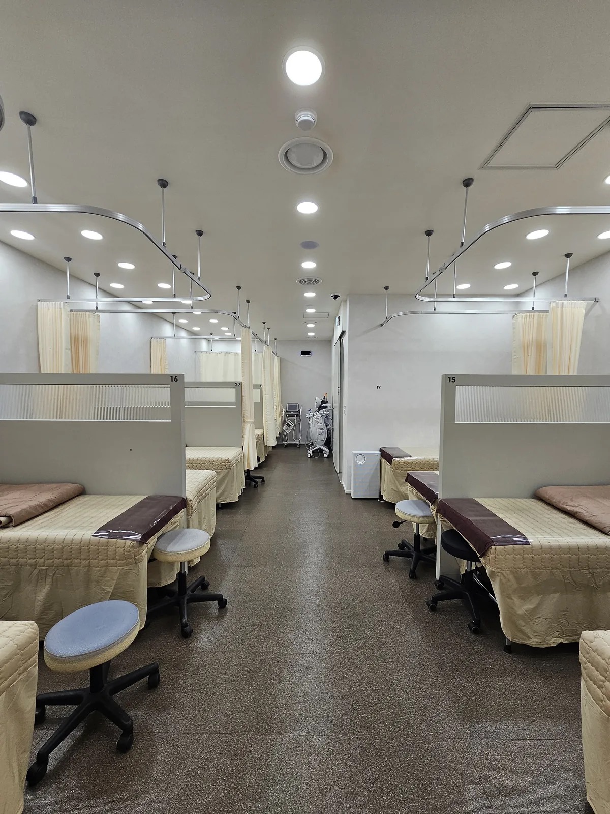 Treatment beds separated by curtains in a clinic room